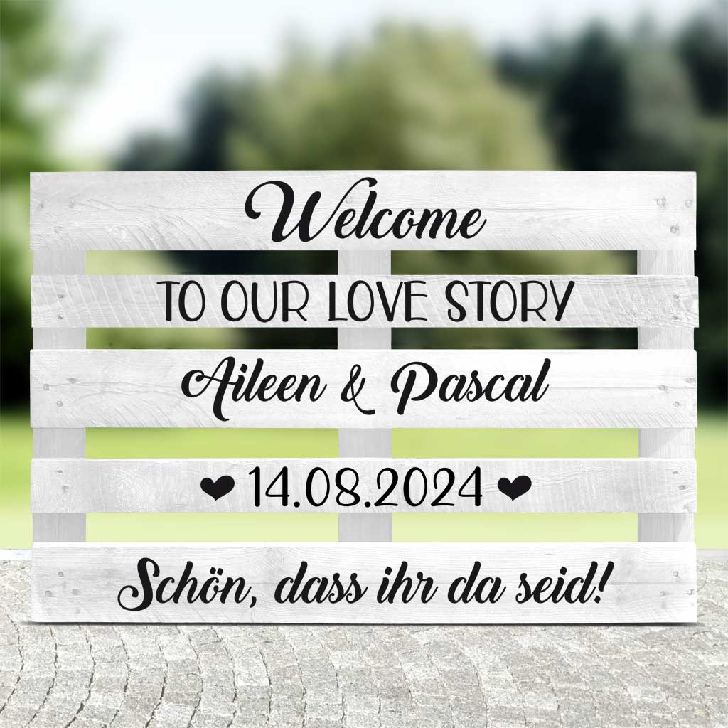 weisse Palette mit schwarzer Schrift "Welcome to our love story" für die Hochzeitsfeier