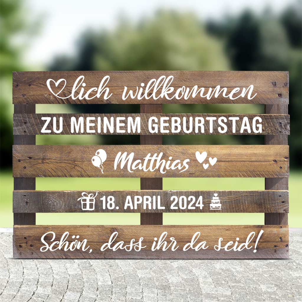 braune Holzpalette mit weissen Textaufklebern zum Geburtstag, personalisiert mit Vornamen und Datum mit Dekoaufklebern (Ballons, Herzen, Geschenk und Torte